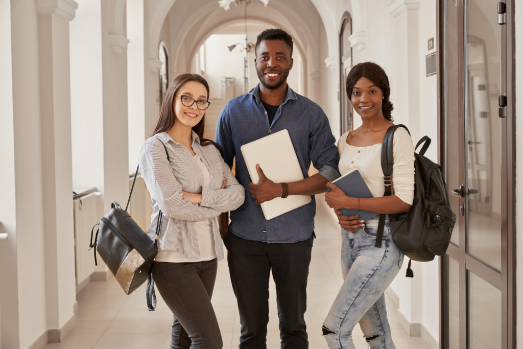 Africans and Caucasian standing on corridor of university.