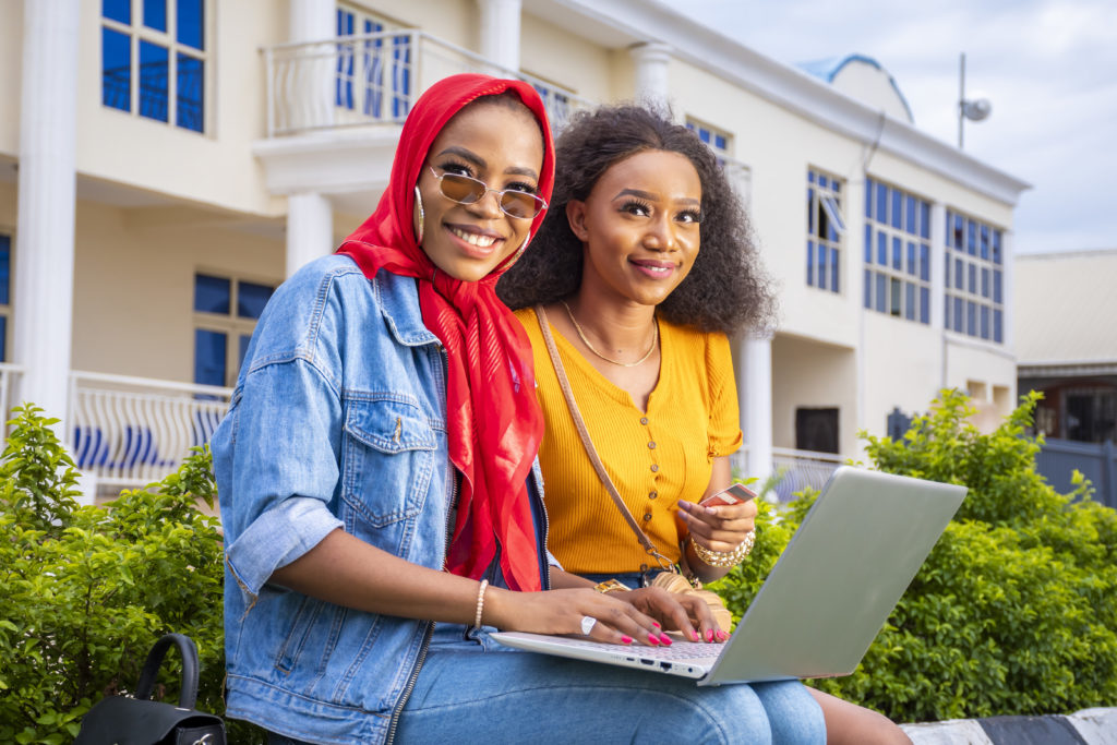 Closeup shot of beautiful young ladies using a laptop