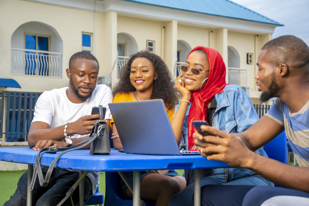 Group of young African people hanging out in an outdoor cafe